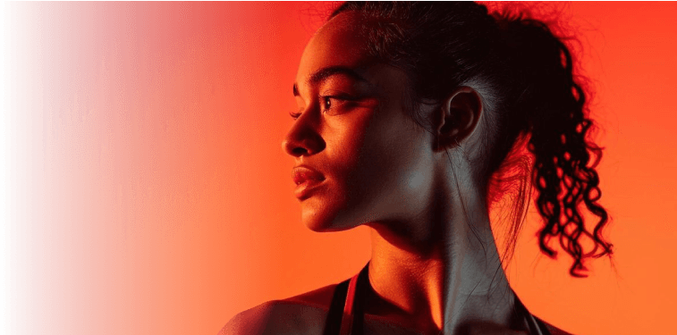 Woman in profile against an orange background